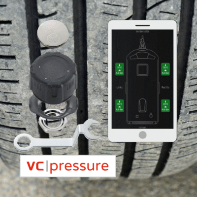 Ein Fahrzeugreifen mit einem Fahrzeugsensor darauf, der vc pressur Sensor und daneben ein Handy mit der Sensor Anzeige.